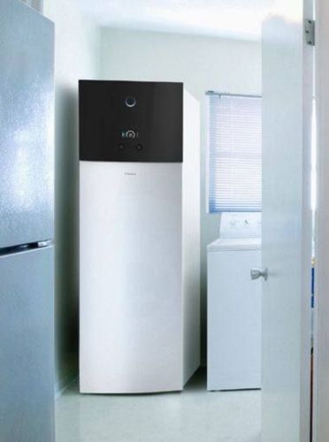 Pompe à chaleur air-eau installée à l'intérieur d'une maison, dans une buanderie.